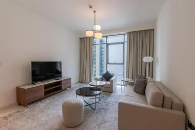 a living room with a couch and a tv at Beachfront Holiday 1BR Sea Marina Views in Dubai