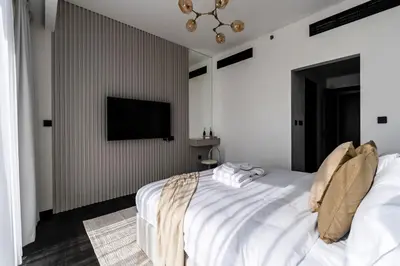 a bedroom with a bed and a tv on a wall at Stylish 1BR with Dubai Skyline & Burj Khalifa View in Dubai