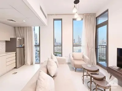 a living room with white furniture and large windows at Luxurious 1BR Apt with Balcony in Production City in Dubai