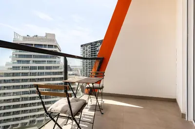 a balcony with two chairs and a table on a building at Binghatti Gateway Family 2BR with Balcony, Close to Dubai Mall & Burj Khalifa by Simply Comfort in Dubai