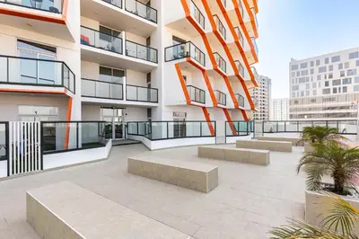 an apartment patio with benches in front of a building at Binghatti Gateway Family 2BR with Balcony, Close to Dubai Mall & Burj Khalifa by Simply Comfort in Dubai