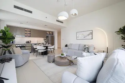 a living room with white furniture and a kitchen at High-Rise Chic, Burj Crown, Opera Boulevard View, by Dubai Mall in Dubai