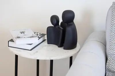 two black sculptures sitting on a table next to a couch at High-Rise Chic, Burj Crown, Opera Boulevard View, by Dubai Mall in Dubai