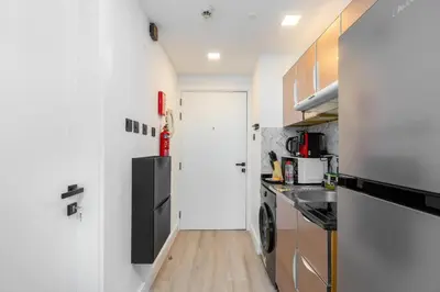 a small kitchen with a refrigerator and a sink at Nice studio in JVT - Al Manara Tower - Dubai in Dubai