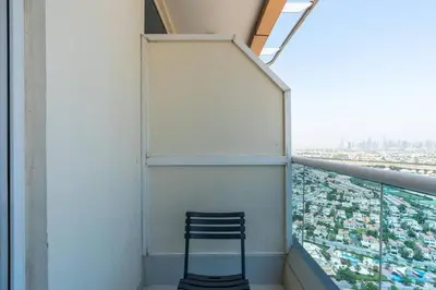 a chair sitting on the balcony of a building at Nice studio in JVT - Al Manara Tower - Dubai in Dubai