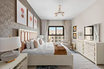 a white bedroom with a bed and a window at Brand New 2 Br Apartment In Family Community in Dubai