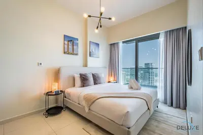 a bedroom with a large bed and a large window at Special Deal 2BR with Canal Views & Relaxing Balcony by Deluxe Holiday Homes in Dubai