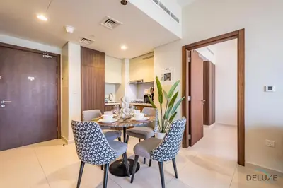 a dining room with a table and chairs at Special Deal 2BR with Canal Views & Relaxing Balcony by Deluxe Holiday Homes in Dubai