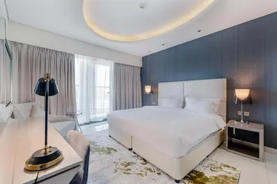 a bedroom with a white bed and a blue wall at ALiving Modern & Chic 1BR I Paramount Tower D -2203 in Dubai