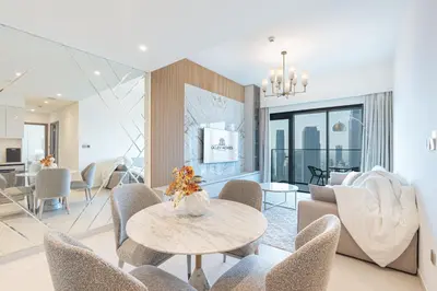 a living room with a table and chairs at Luxury Home on the 50th Floor with Full Burj View in Dubai