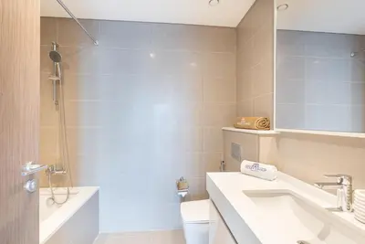 a bathroom with a sink and a tub and a toilet at Luxury Home on the 50th Floor with Full Burj View in Dubai