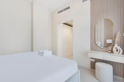 a white bathroom with a vanity and a mirror at Burj Khalifa View Big terrace 1BR in Prime Views in Dubai