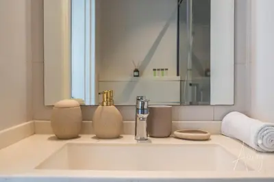 a bathroom sink with two soap dispensers and a mirror at Burj Khalifa View Big terrace 1BR in Prime Views in Dubai