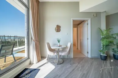 a dining room with a table and chairs and a window at Burj Khalifa View Big terrace 1BR in Prime Views in Dubai