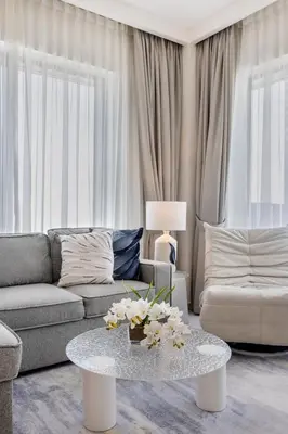 a living room with a couch and a table with flowers on it at Creekside Bliss 1BR with Beach Access Summer 3 in Dubai