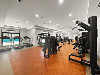 a gym with many treadmills and machines in a room at A Living One 1BR Apartment At Asayel 3, Madinat Jumeirah in Dubai