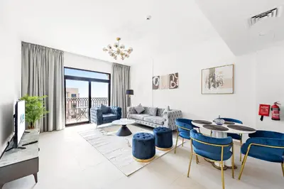 a living room with a couch and a table and chairs at A Living One 1BR Apartment At Asayel 3, Madinat Jumeirah in Dubai
