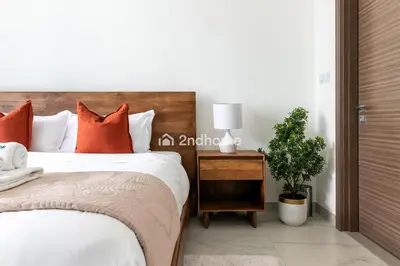 a bedroom with a bed with orange pillows and a plant at Fully Equipped Residence at One Park Avenue in Dubai