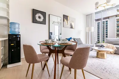 a kitchen and living room with a table and chairs at Fully Equipped Residence at One Park Avenue in Dubai