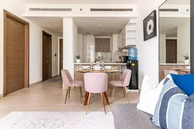 a kitchen and dining room with a table and chairs at Fully Equipped Residence at One Park Avenue in Dubai