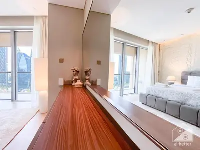 a bedroom with a bed and large windows at Dubai Mall Downtown Luxury stay with Balcony & View in Dubai