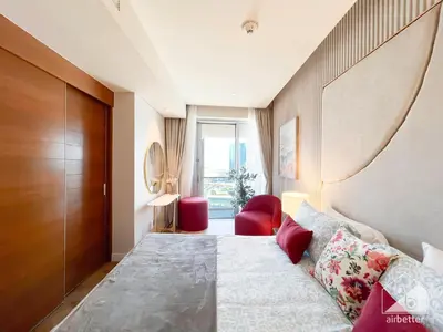 a hotel room with a large bed and red chairs at Dubai Mall Downtown Luxury stay with Balcony & View in Dubai