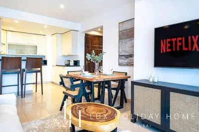 a living room with a table and a kitchen at LUX The Bonnington JLT Suite 2 in Dubai