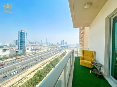 a balcony with a yellow chair and a highway at Royalton - Tranquil 15th-Floor Apartment with City Views in Dubai