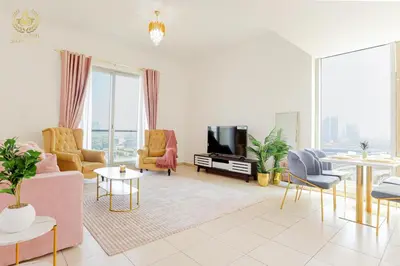 a living room with a pink couch and chairs at Royalton - Tranquil 15th-Floor Apartment with City Views in Dubai