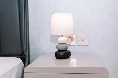 a lamp sitting on top of a table in a bedroom at WelHome - Opulent Retreat With Panoramic Cityscape Views in Dubai