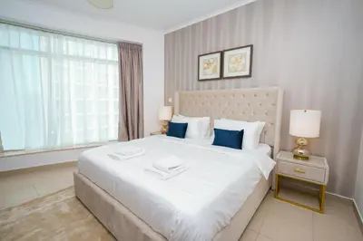 a bedroom with a large white bed with blue pillows at Lovely 1BHK in Burj views tower near Dubai mall in Dubai