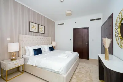 a bedroom with a large white bed and a table at Lovely 1BHK in Burj views tower near Dubai mall in Dubai