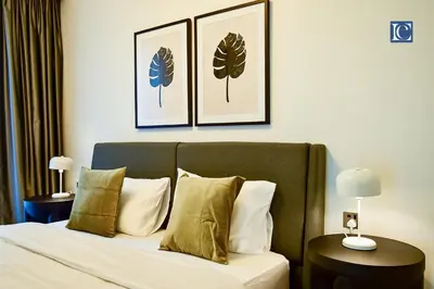 a bedroom with a bed with two pictures on the wall at Luxury Escapes - ME DO RE Tower JLT in Dubai