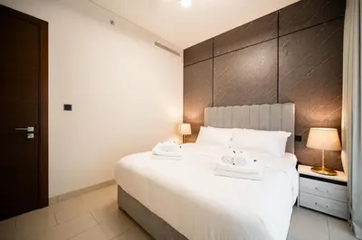 a bedroom with a large white bed with two towels on it at SettlerHomes - Serene Downtown Stay on the High-Floor in Dubai