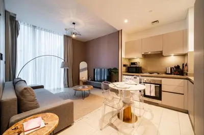a kitchen and living room with a couch and a table at SettlerHomes - Serene Downtown Stay on the High-Floor in Dubai