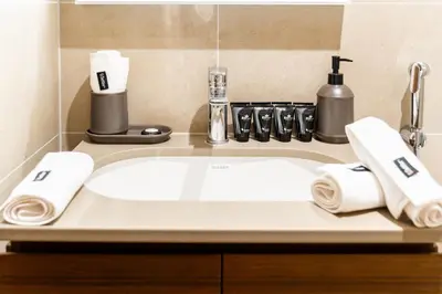 a bathroom sink with towels on a counter at SettlerHomes - Serene Downtown Stay on the High-Floor in Dubai