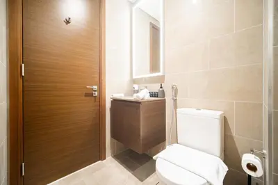 a bathroom with a toilet and a sink at SettlerHomes - Serene Downtown Stay on the High-Floor in Dubai