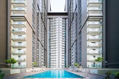 an apartment complex with a swimming pool in front of two tall buildings at SettlerHomes - Serene Downtown Stay on the High-Floor in Dubai