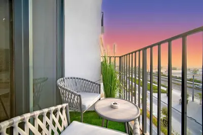 a balcony with a table and chairs and a view at SettlerHomes - Serene Golfville Escape near Parkside in Dubai