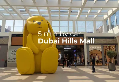 a large yellow teddy bear statue in a mall at SettlerHomes - Serene Golfville Escape near Parkside in Dubai