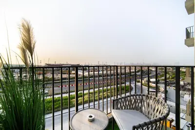 a balcony with a table and chairs and a view of a highway at SettlerHomes - Serene Golfville Escape near Parkside in Dubai