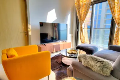 a living room with a couch and chairs and a tv at Business Bay Retreat in Dubai