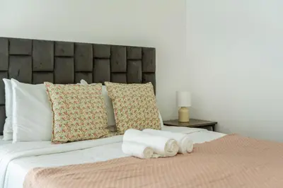 a bed with two rolled towels on top of it at ShoresInn - Elegant 1BR in Dubai Marina in Dubai