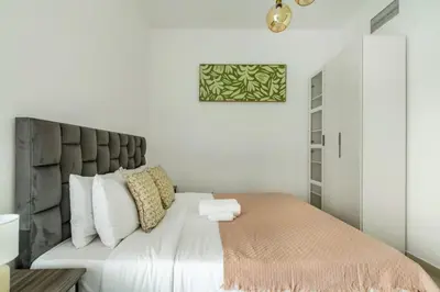 a bedroom with a large bed with white pillows at ShoresInn - Elegant 1BR in Dubai Marina in Dubai