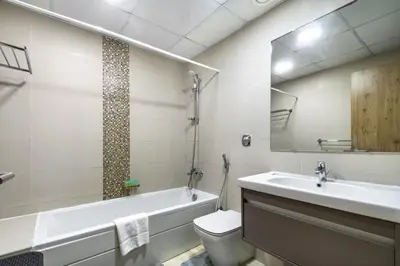 a bathroom with a tub and a toilet and a sink at ShoresInn - Elegant 1BR in Dubai Marina in Dubai