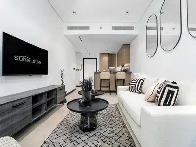a living room with a white couch and a tv at Exceptional 1Bedroom with Premium Amenities in Dubai