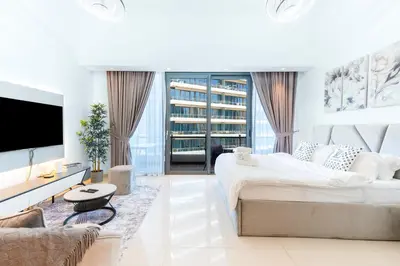 a white bedroom with a large bed and a tv at Luxury Apartment in Dubai Marina w Stunning View in Dubai