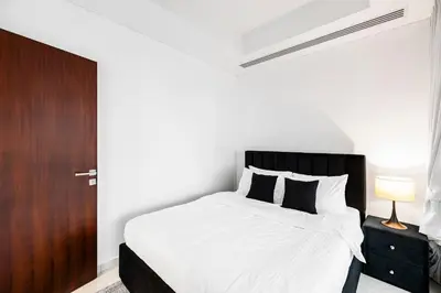 a bedroom with a bed and a wooden door at 2BR City View Bay Square B13 in Dubai