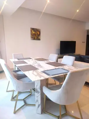 a dining room table with white chairs and a television at Upgraded 2 bedroom at Dubai Marina in Dubai