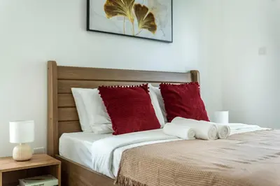a bedroom with a bed with red and white pillows at ShoresInn - Stylish Space in Dubai Marina in Dubai